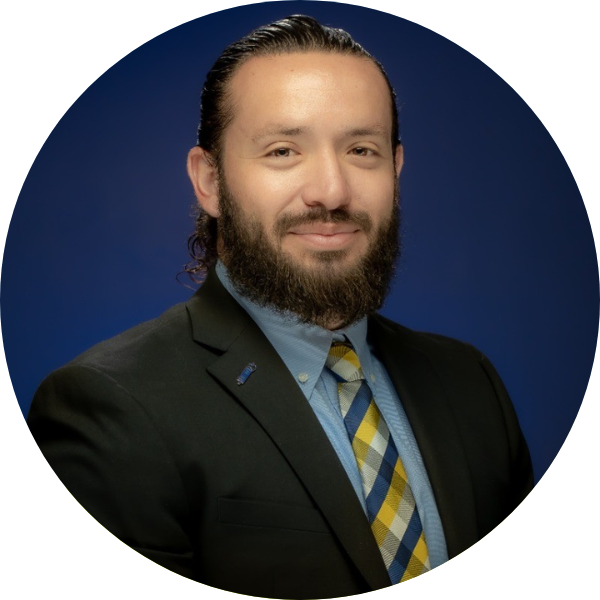 Man with a beard smiling with a blue background.