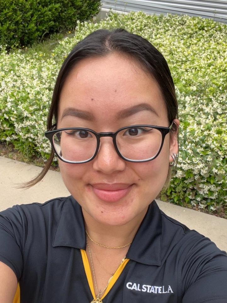 Student with glasses smiling.