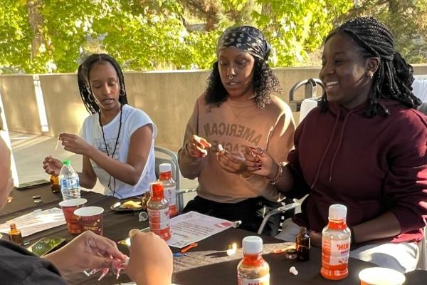 A group of students smiling and observing a spray bottle.